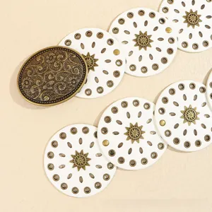 Dettaglio fibbia in bronzo vintage con incisioni floreali su cintura bohémien