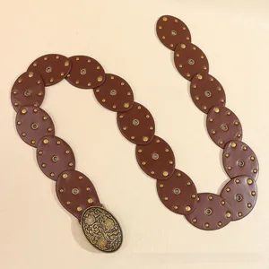 Vue détaillée d'une ceinture Y2K en similicuir avec boucle florale gravée en bronze