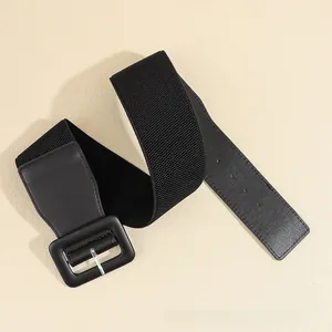 Detailed view of wide black elastic waist belt with silver buckle and leather accents