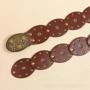 Détail de ceinture en cuir vintage avec pièces ovales et boucle dorée gravée de fleurs