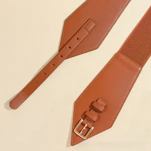 Detail eines braunen elastischen Damengürtels mit goldener Metallschnalle und Lederakzenten