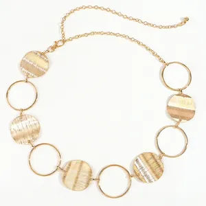 Detailed shot of hollow circles and textured gold metal discs on adjustable waist chain