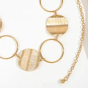 Detail of a vintage golden chain belt with hollow rings and brushed texture discs