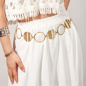 Detail of vintage gold-plated hollow disc chain belt on waist showing metallic texture