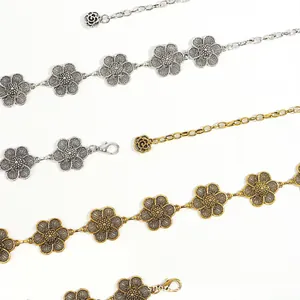 Detailed macro of vintage hollow flower metal waist chain with rose pendant and clasp