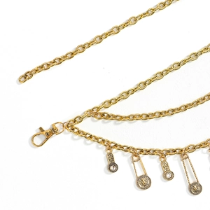 Detail view of multi-layer gold chain belt with lion head coins and sun charms