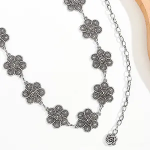 Detail of vintage silver metal flower waist chain with rose pendant and retro finish