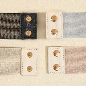Detail of elastic waist belts featuring metallic fibers and leather ends with snap buttons