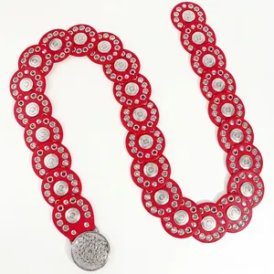 Detail van rode leren riem met zilveren metalen gesp in vintage bloemenpatroon