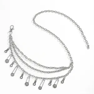 Detailed close-up of multi-layer silver metal waist chain with coin and paperclip charms