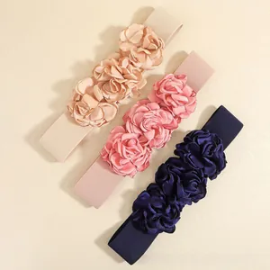 Detail view of elastic waist belts featuring three elegant satin 3D floral accents