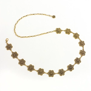 Detail of vintage gold flower waist chain with hollowed floral links and rose charm