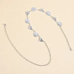 Detailed macro view of silver seashell and conch charms on adjustable metal waist chain