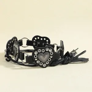 Detail of black leather heart-shaped belt with silver metal grommets and ring connectors