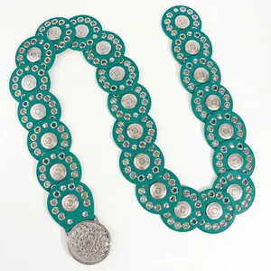 Detail van boheemse riem met pauwgroene leren cirkels en zilveren reliëf gespsluiting