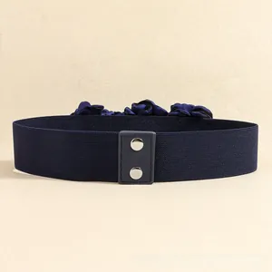 Close-up of three dark blue silk rose flowers on an elastic waist belt with metal studs