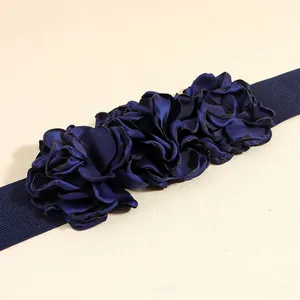 Detail of navy blue elastic waist belt featuring three 3D handmade satin flower accents