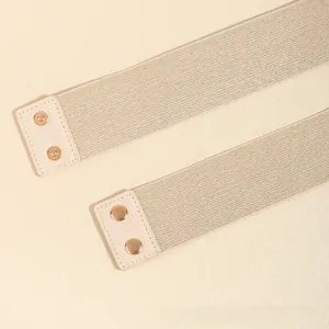Detail of champagne gold elastic waist belt with rose gold snap buttons and leather ends