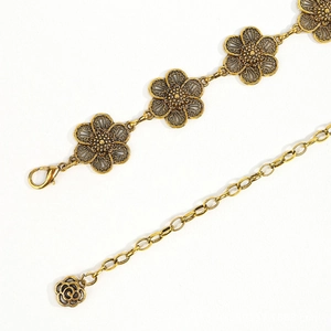 Close-up of vintage gold flower waist chain with carved petals and rose pendant