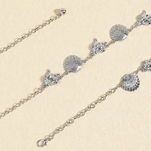Detail of silver bohemian waist chain with seashell and conch metal pendants