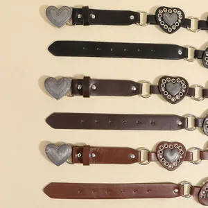 Flat lay of vintage bohemian leather belts with heart buckles and metal ring accents