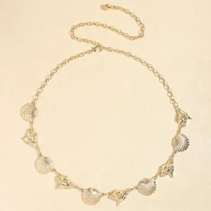 Detail of bohemian gold waist chain featuring metallic seashells and conch ornaments