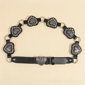 Close-up of bohemian black leather belt featuring vintage heart-shaped metal studs
