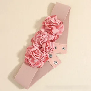 Detail of pink elastic waist belt featuring three satin roses and silver metal snap buttons