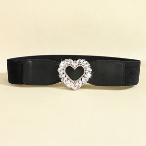 Detailed view of women's elastic belt with large heart-shaped rhinestone buckle decoration