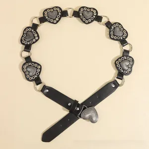 Detail of bohemian black leather belt with embossed silver heart metal plates