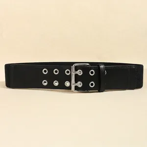 Detail of wide black elastic waist belt with double-row silver eyelets and metal buckle