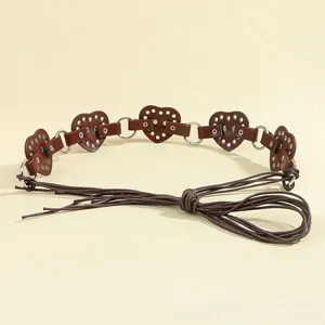 Detail of dark brown heart-shaped leather belt with metal rings and lace-up strap