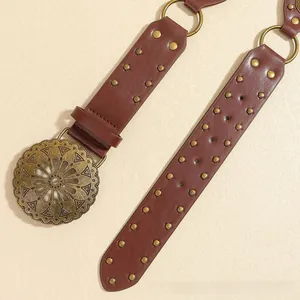 Detail of western retro belt with hollow sunflower metal buckle and bronze rivets