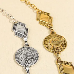Detail of bohemian metal waist chain featuring embossed geometric textures and coins