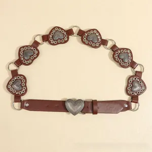Detailed view of bohemian brown belt with vintage metal heart-shaped charms and rings