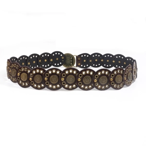 Detail van de bohemian brede leren riem met metalen studs en vintage bloemgesp
