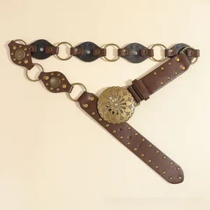 Close-up of vintage Western belt with hollow sunflower buckle and bronze stud accents