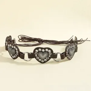 Detail of dark brown bohemian waist belt with heart leather patches and silver metal studs