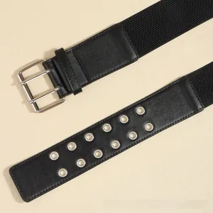 Detail of black wide elastic belt with double silver buckles and metal eyelet accents
