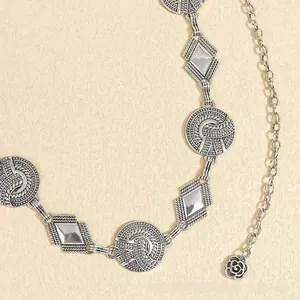 Detail of silver bohemian waist chain with woven round plates and hollow rose pendant