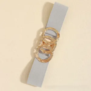 Detail of grey elastic belt with golden interlocking triple ring metal buckle for dresses