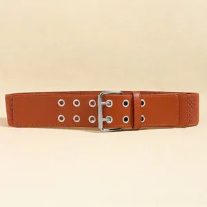 Detail of vintage brown elastic waist belt with double rows of silver eyelets and buckle