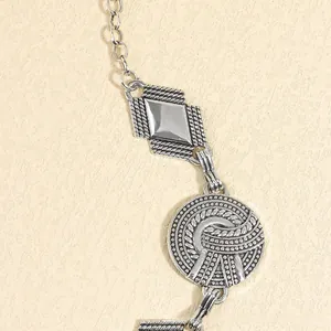 Detail shot of bohemian silver waist chain featuring textured geometric pendants and knots