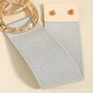 Detail of elegant wide elastic belt with gold wavy rings and silver metallic texture