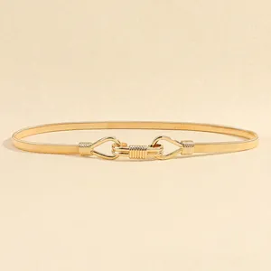Close-up of golden elastic metal waist chain with symmetrical interlocking buckle