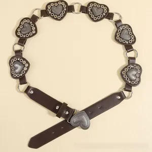 Detail view of heart-shaped metal plates and rivet accents on a vintage brown belt