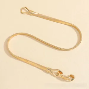 Detailed macro view of golden metal snake chain belt with dual hook buckle