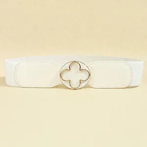 Close-up of white elastic waist belt with gold clover buckle and textured PU leather