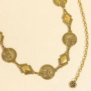 Detail of vintage gold metal waist chain with embossed circles and rose pendant