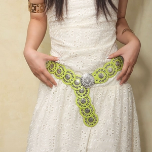 Detail van een bohemien turquoise riem met zilveren metalen gespen op kanten jurk